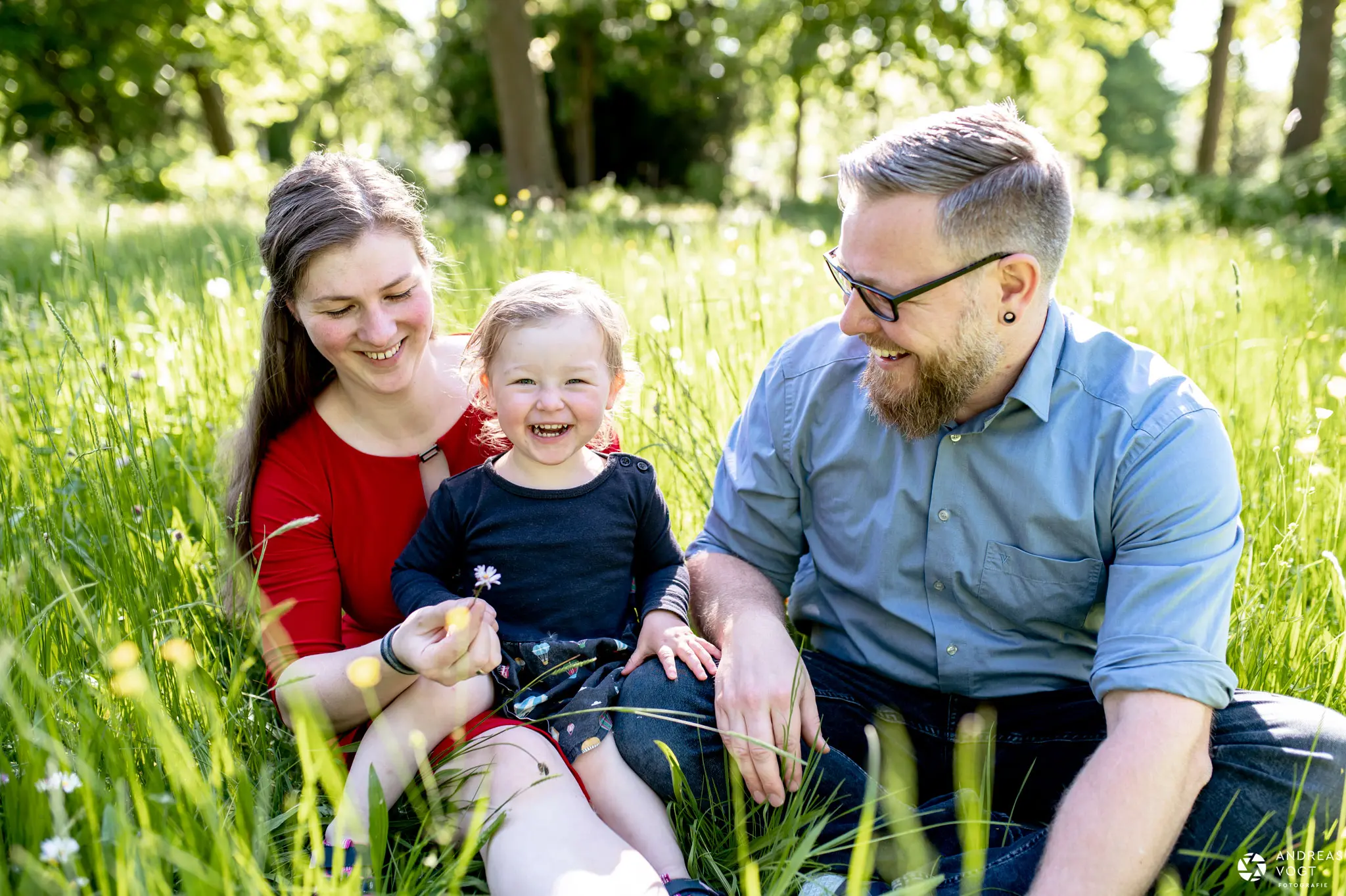 Eltern mit Kind in der Wiese beim Familienfotoshooting - Fotograf Andreas Vogt aus Aalen